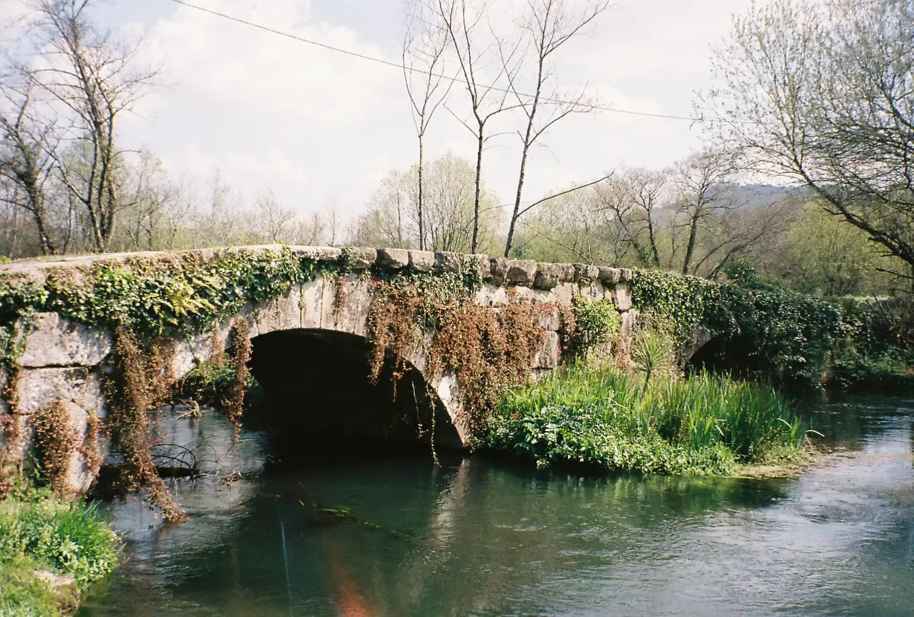 Ancient stone bridge over a calm river